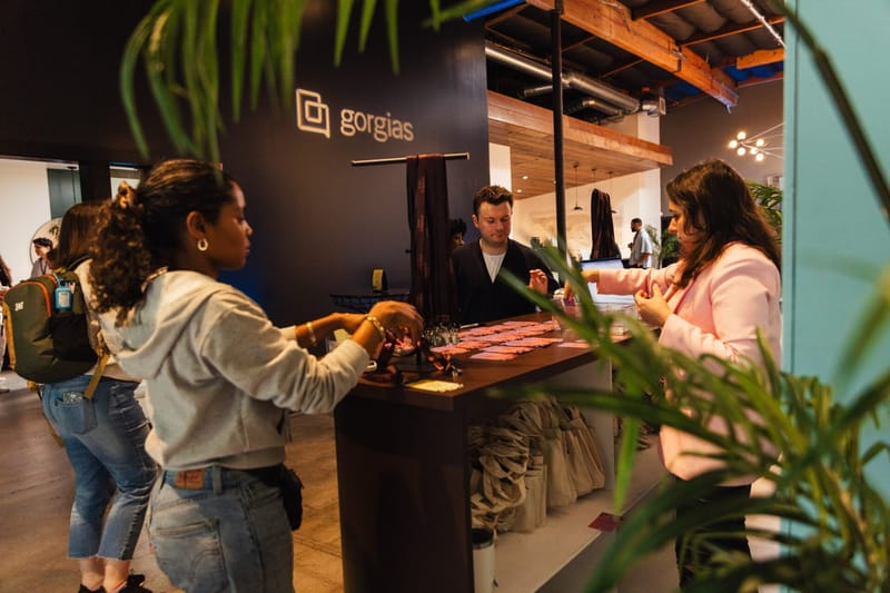 Guests at a Gorgias branded counter beside a potted palm