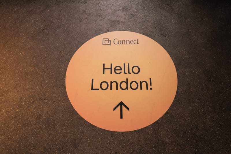 Orange floor decal reading Hello London! with an arrow