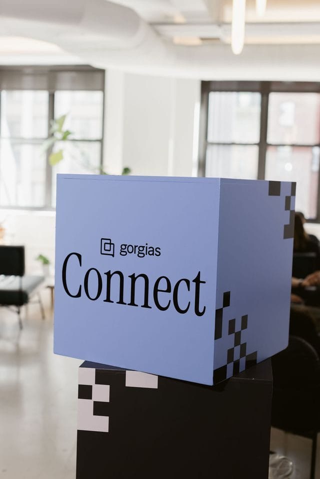 Pale blue cube printed with the Gorgias Connect logo and a pixel checker pattern