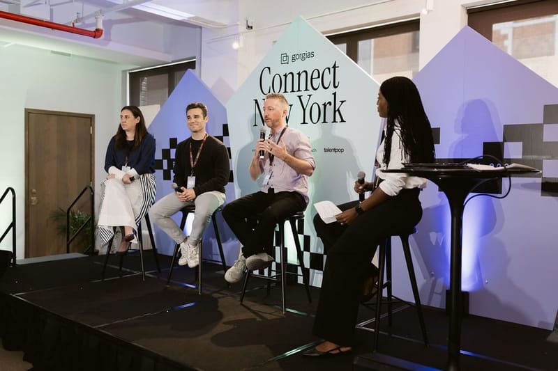 Four panelists on stage, one holding a microphone, in front of the Connect New York panels