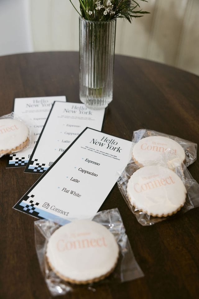 Hello New York coffee menu cards listing espresso, cappuccino, latte and flat white beside wrapped Connect cookies