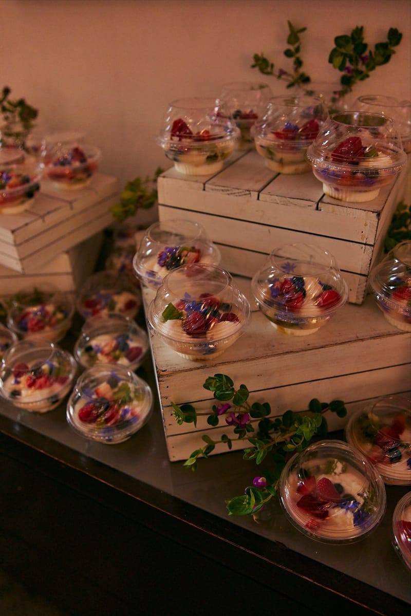 Dessert cups topped with edible flowers set on wooden crates