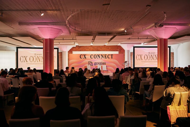 Packed audience facing the CX Connect stage and screens