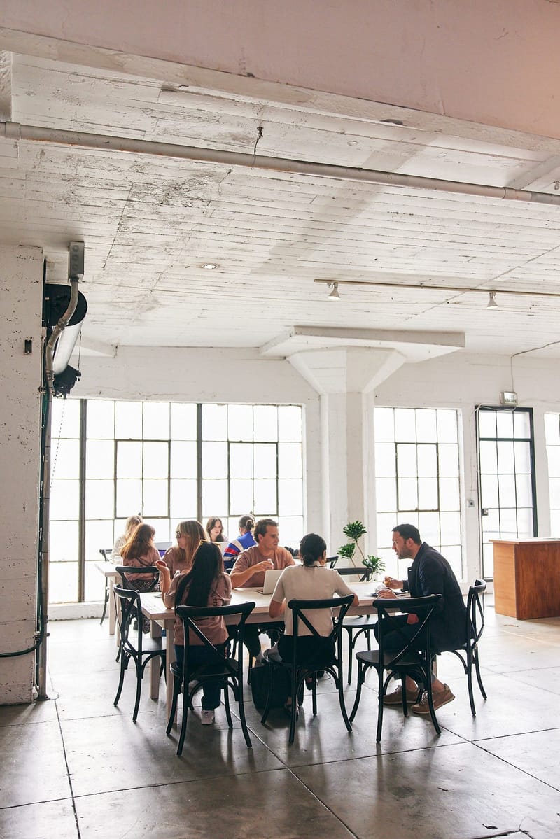 Guests talking around a round table in a bright loft