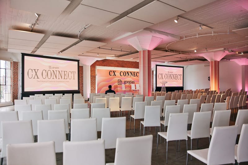 Rows of empty white chairs facing the CX Connect stage