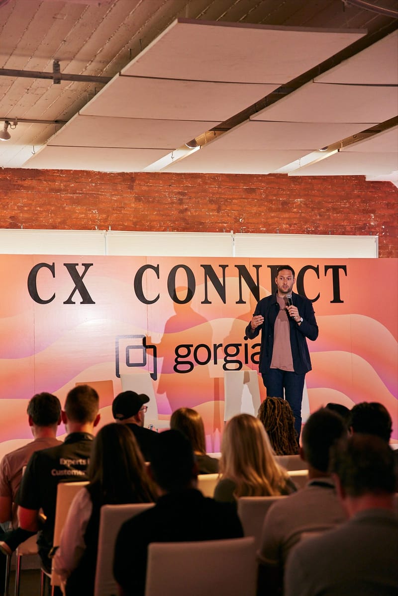 A speaker presenting in front of a CX Connect backdrop
