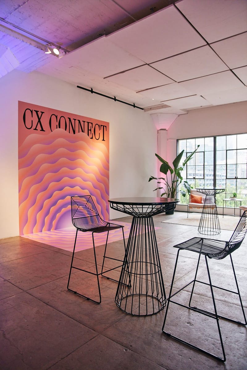 Pink and purple CX Connect wave wall with wire bar stools
