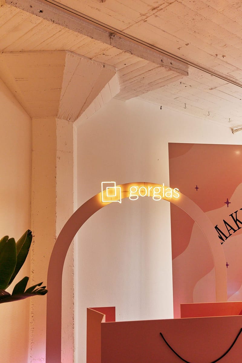 Neon Gorgias sign on an arch above a shopping bag shaped box