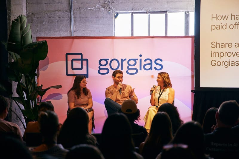 Three-person panel seated in front of a pink Gorgias backdrop