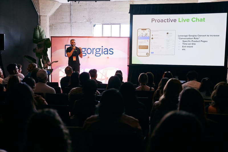 A speaker presenting a Proactive Live Chat slide in front of a Gorgias backdrop
