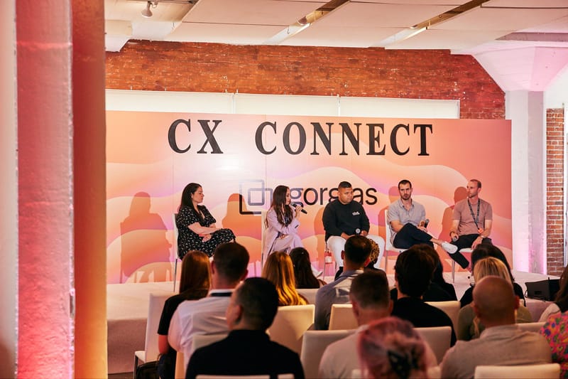 Five-person panel seated on the CX Connect stage