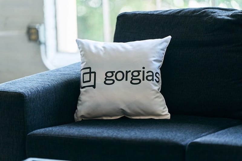 White Gorgias pillow on a navy sofa