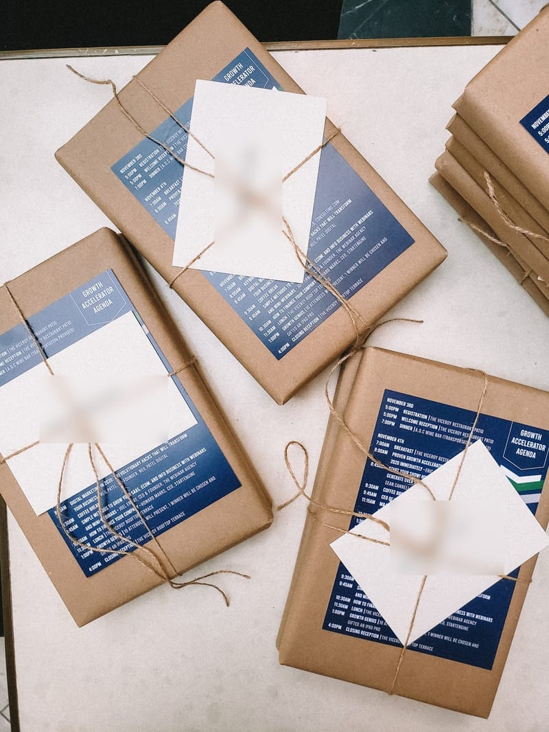 Kraft paper packets printed with the Growth Accelerator Agenda, tied with twine and tagged with handwritten name cards