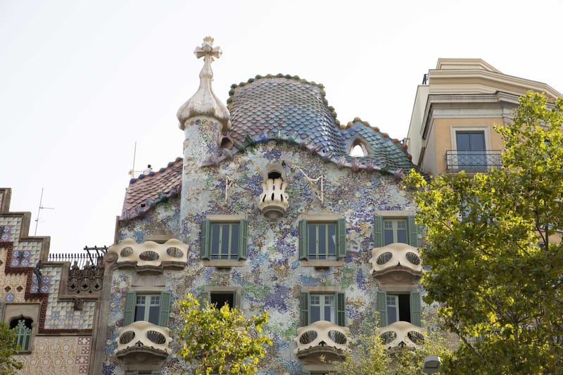 Casa Batlló facade with colorful mosaic tiles, curved balconies and a scaled roof
