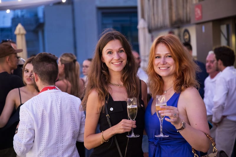 Two guests smiling with glasses of champagne