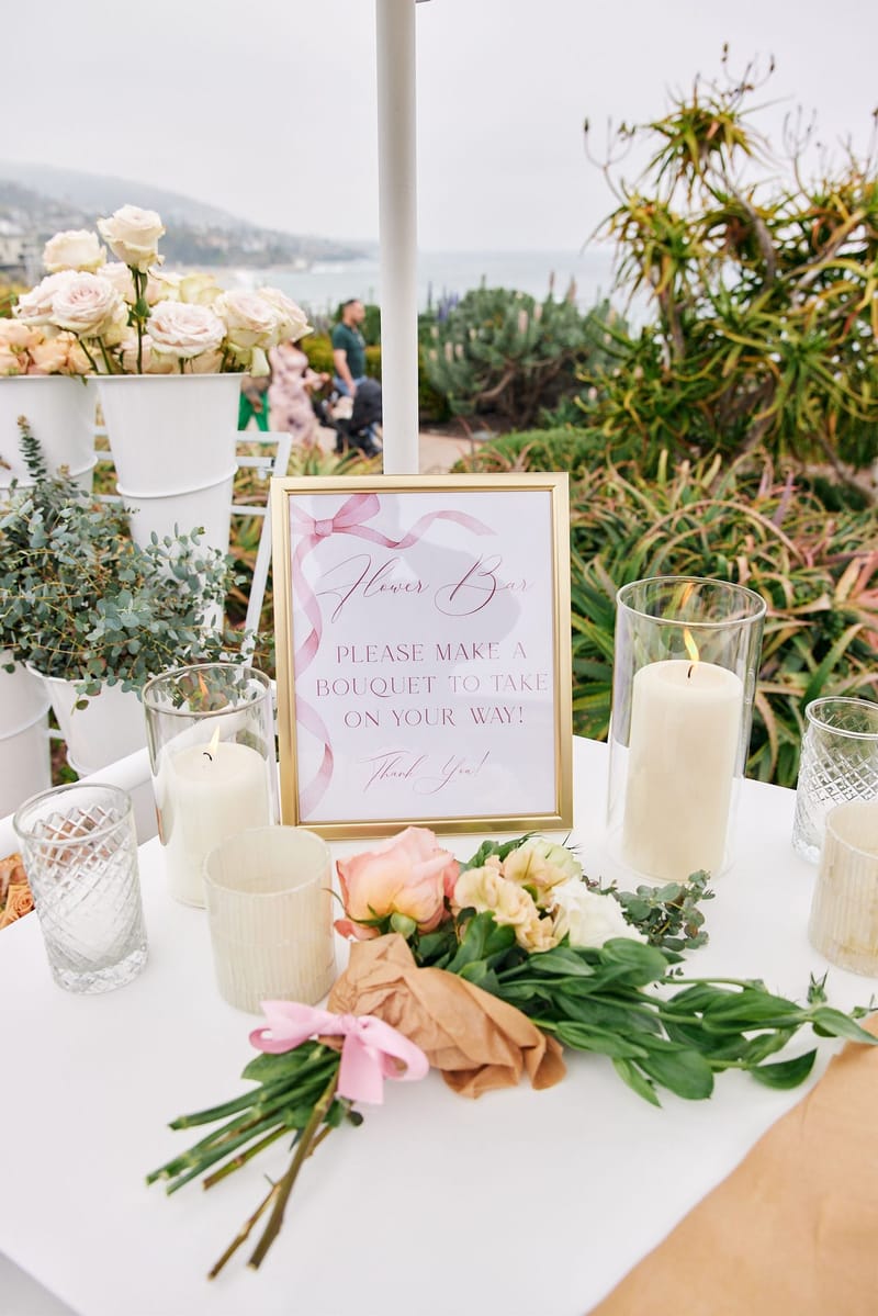 Gold-framed Flower Bar sign reading Please make a bouquet to take on your way! with pillar candles and roses