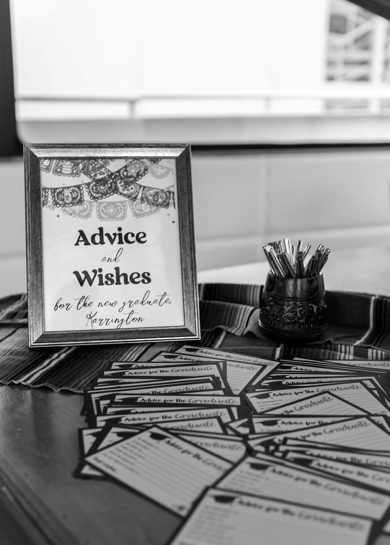Black and white framed Advice and Wishes sign for the new graduate, Karrington, over advice cards