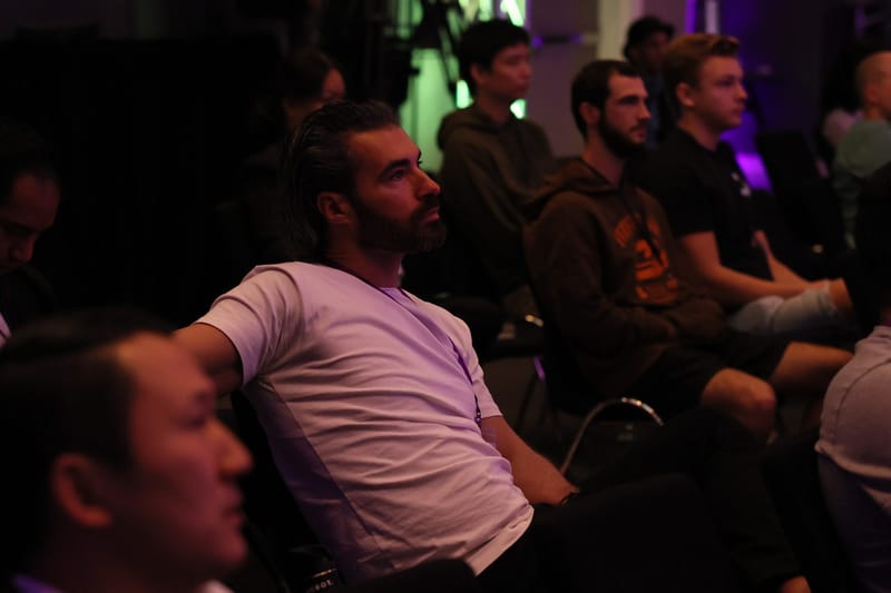 Guests listening closely from their seats in a dimly lit session room