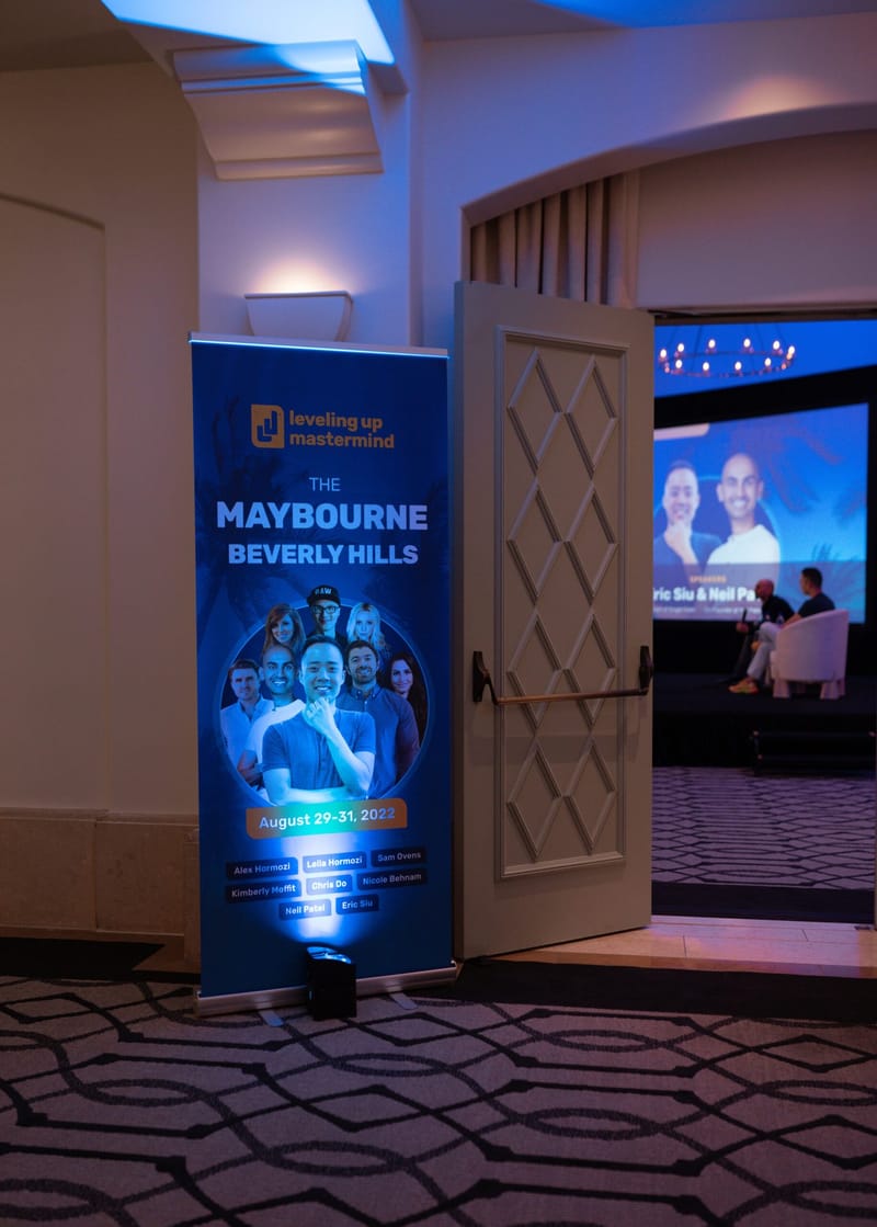 Leveling Up Mastermind banner for The Maybourne Beverly Hills beside an open door to the session room