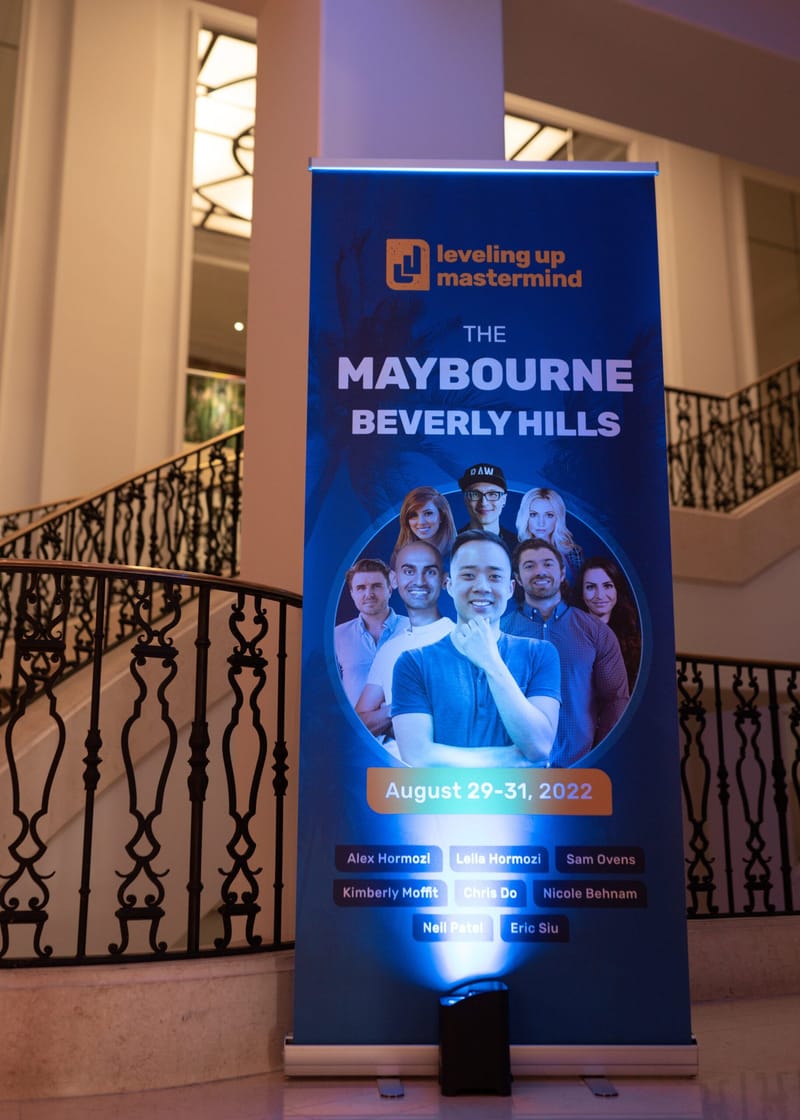 Leveling Up Mastermind banner listing the speakers and August 29-31, 2022 beside a curved staircase