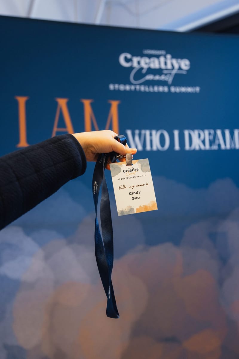 A hand holding a Storytellers Summit name badge