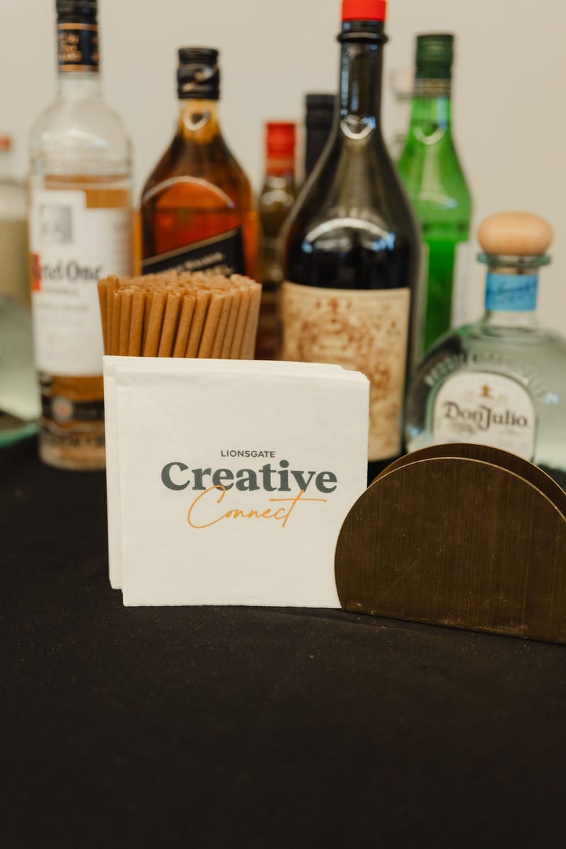 Bottles of spirits behind a Creative Connect napkin on the bar