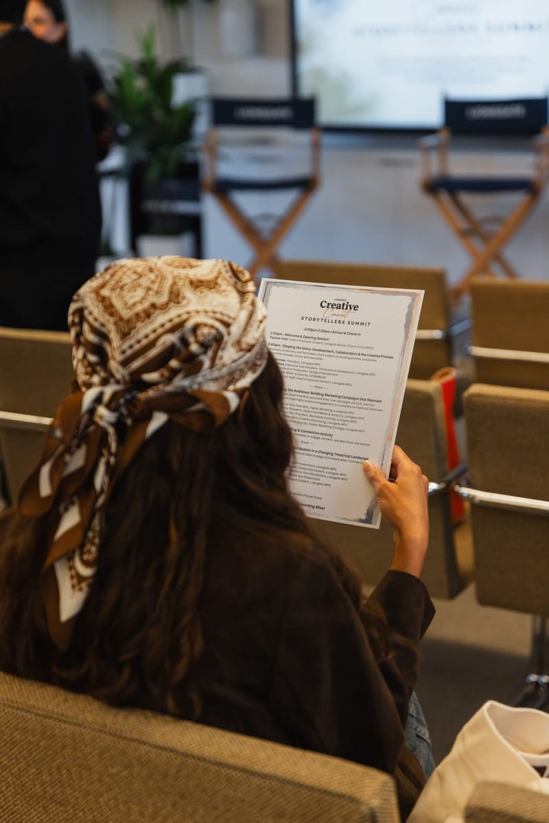 A guest reading a printed program during the summit
