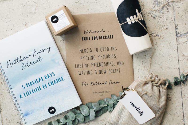 Welcome kit with a Matthew Hussey Retreat notebook, a Welcome to Fort Lauderdale card and a bag tagged essentials