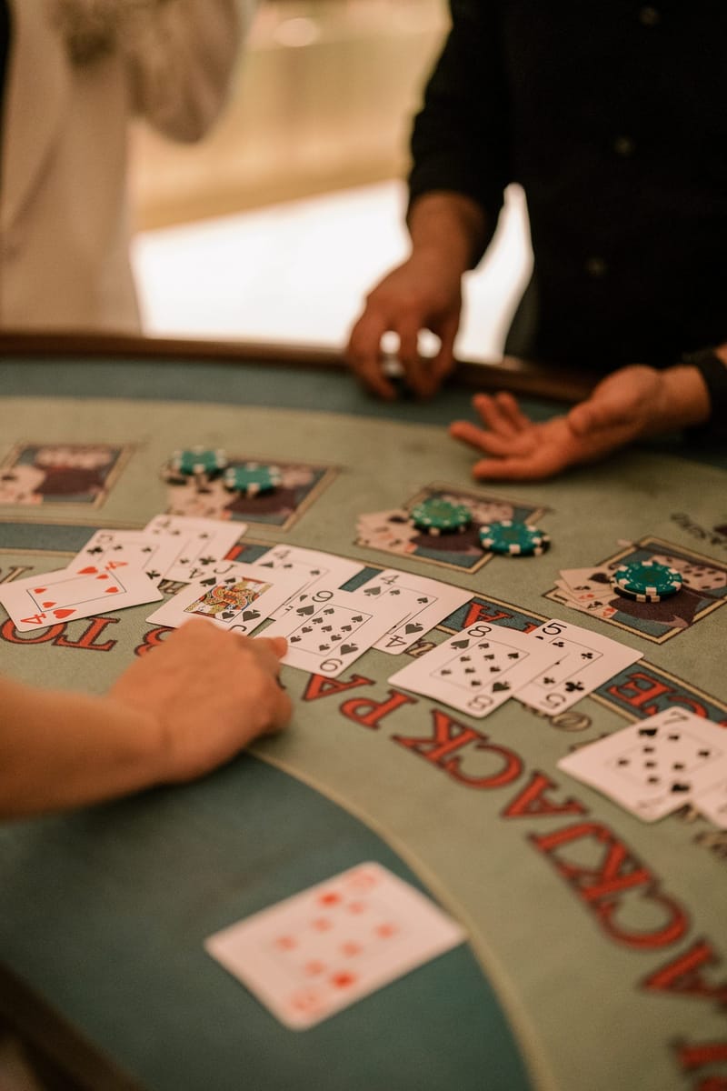 Dealer's hands laying out playing cards and chips on a blackjack table