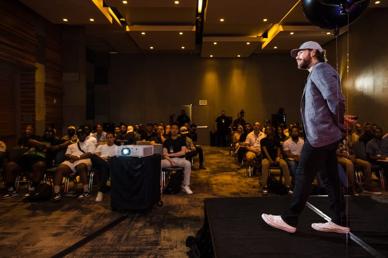 Speaker stepping along the edge of the stage as a full room of attendees watches
