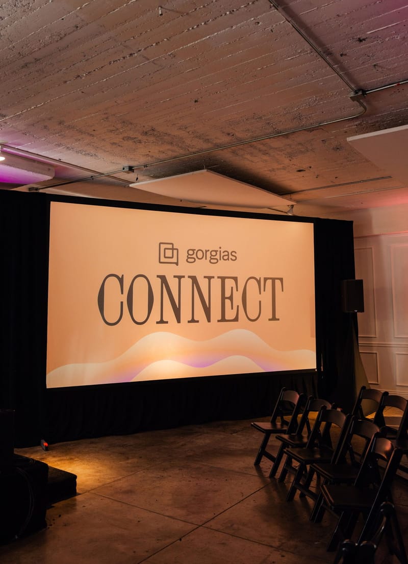 Screen reading Gorgias Connect beside rows of black folding chairs