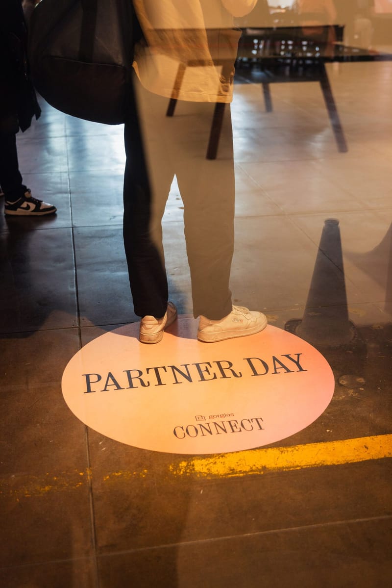 Round floor projection reading Partner Day and Gorgias Connect beside a guest's sneakers