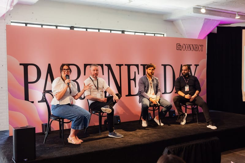 Four panelists seated on the PARTNER DAY stage