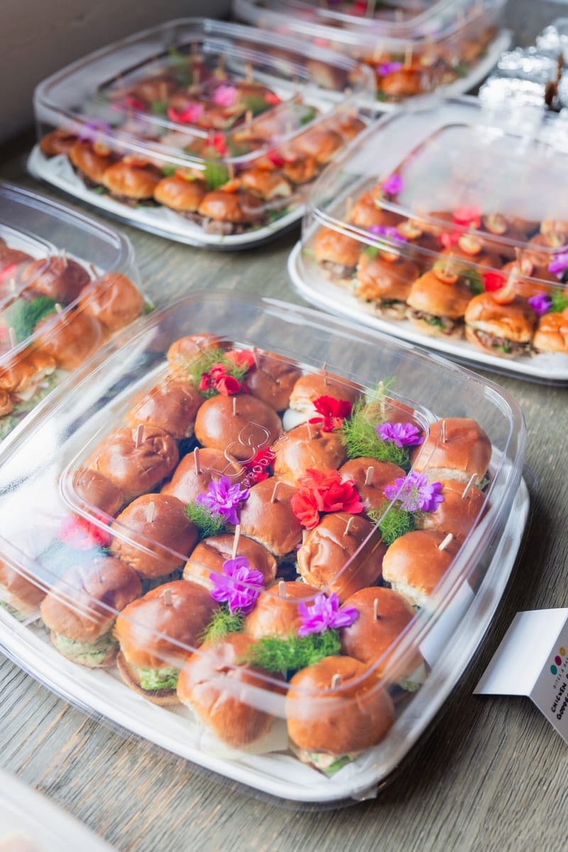 Clear trays of sliders topped with purple and red flowers