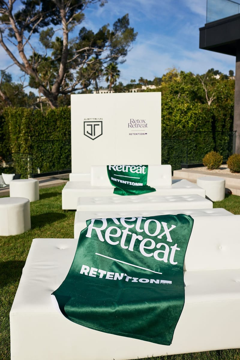 Green Retox Retreat towel on white lounge seating beside a sign with a JT shield logo
