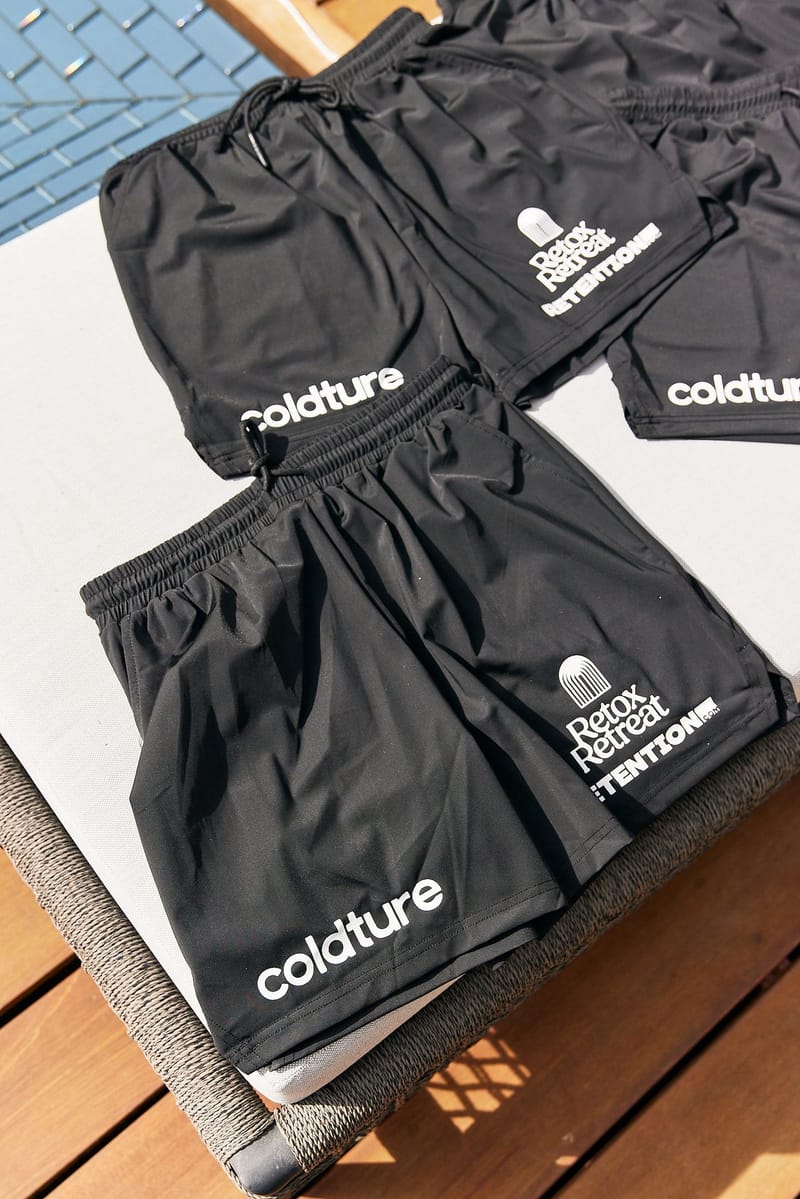 Black Coldture shorts printed with Retox Retreat and Retention laid out on a lounger