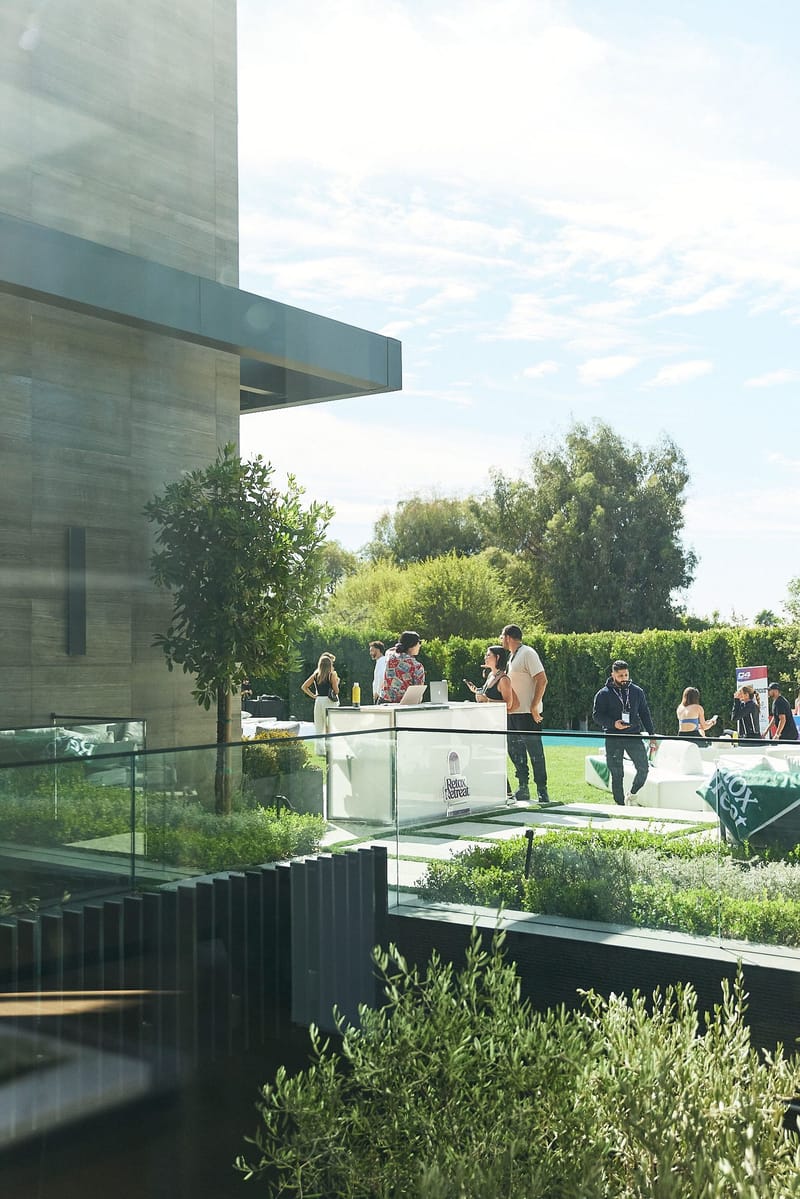 View down from the house to guests gathered at white tables in the garden
