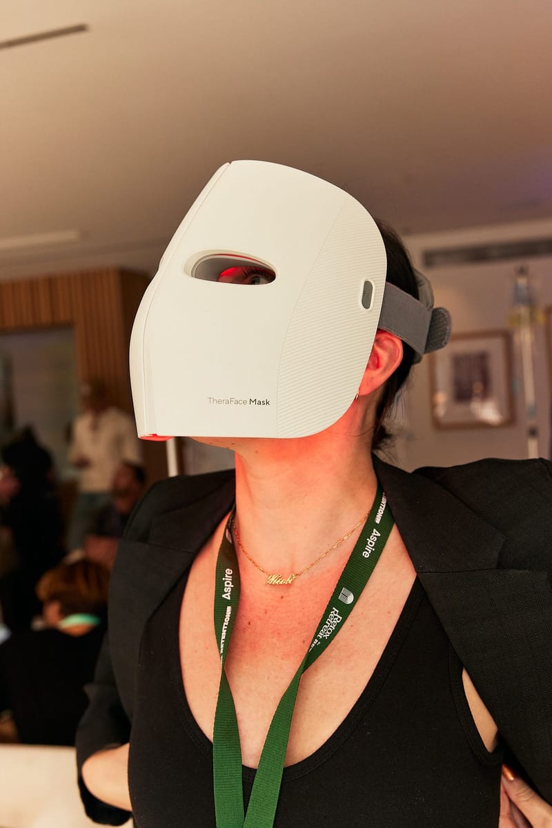 Guest with an Aspire lanyard wearing a white face mask device