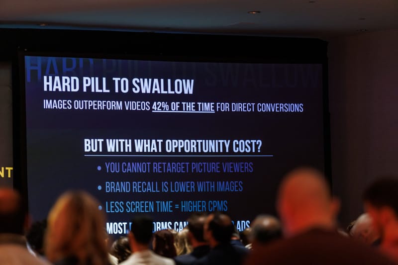 Audience watching a slide titled Hard Pill to Swallow on a large screen