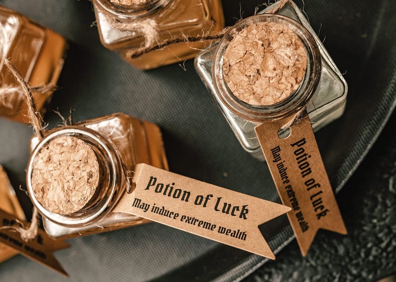 Corked glass jars tied with twine and tagged Potion of Luck, May induce extreme wealth