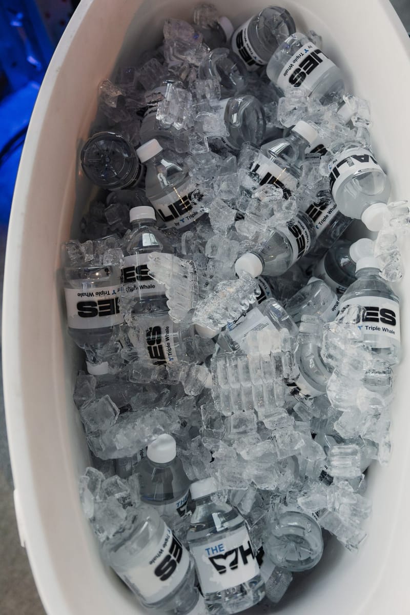 Ice bin full of bottled water labeled The Whalies by Triple Whale
