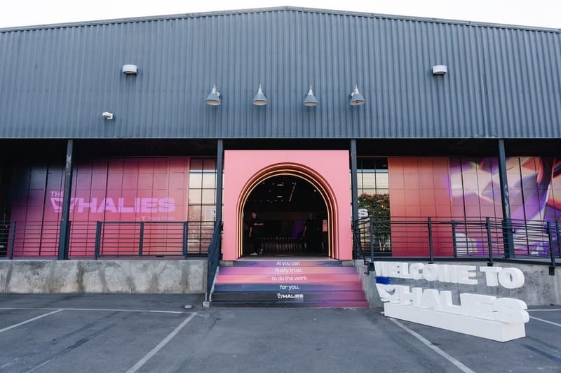 Venue exterior wrapped in pink Whalies branding, with a lit tunnel entrance and Welcome to Whalies letters
