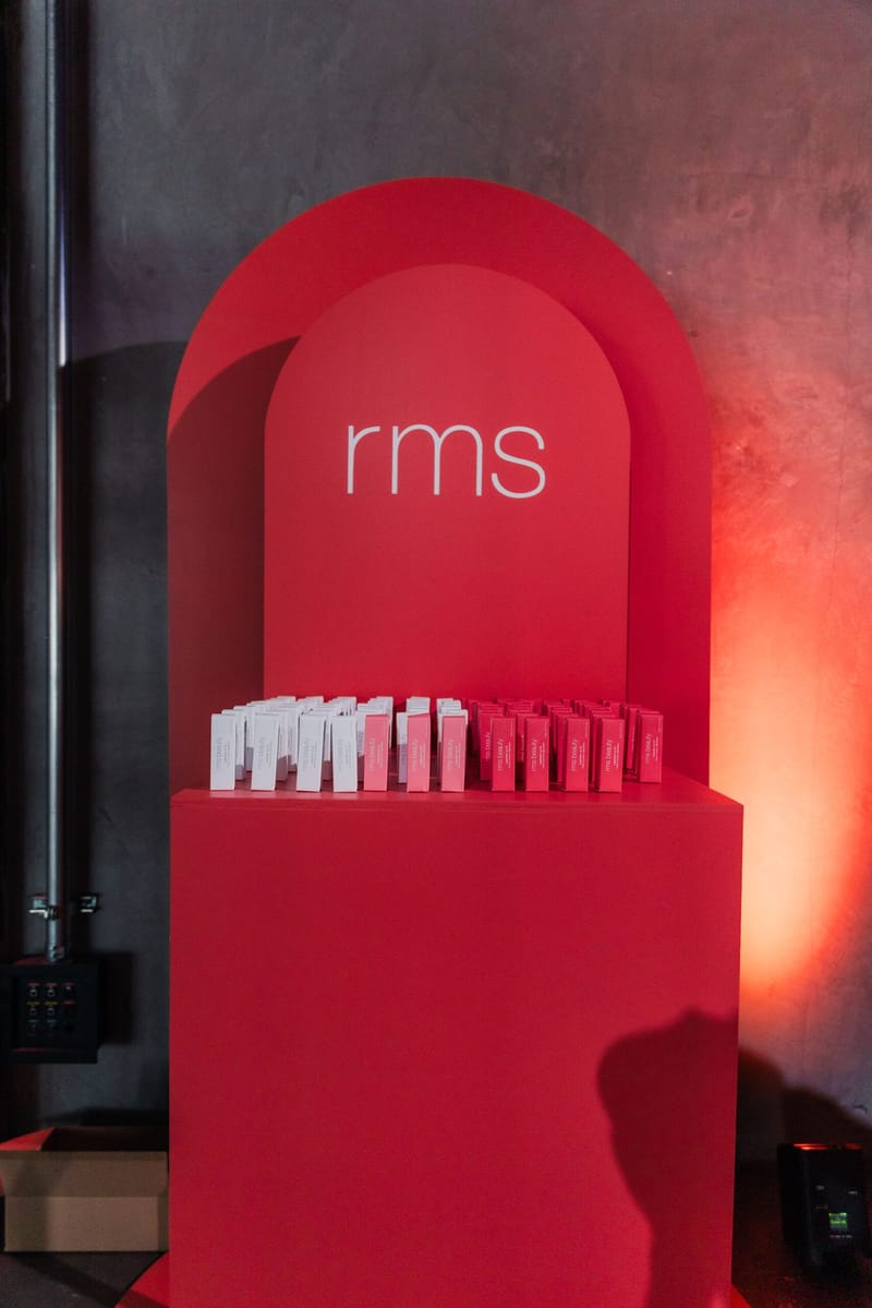 Red arch-shaped rms display holding rows of small product boxes