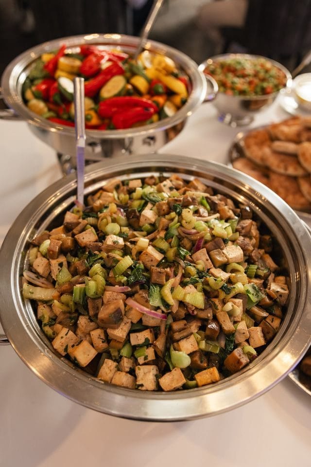Buffet bowls of chopped salad and roasted mini peppers