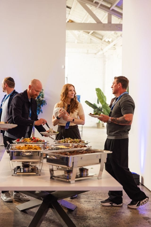 Guests serving themselves from chafing dishes at a buffet table