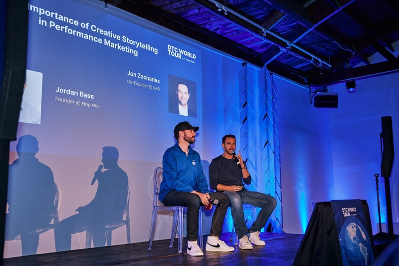 Two panelists on clear chairs below a slide on the importance of creative storytelling in performance marketing