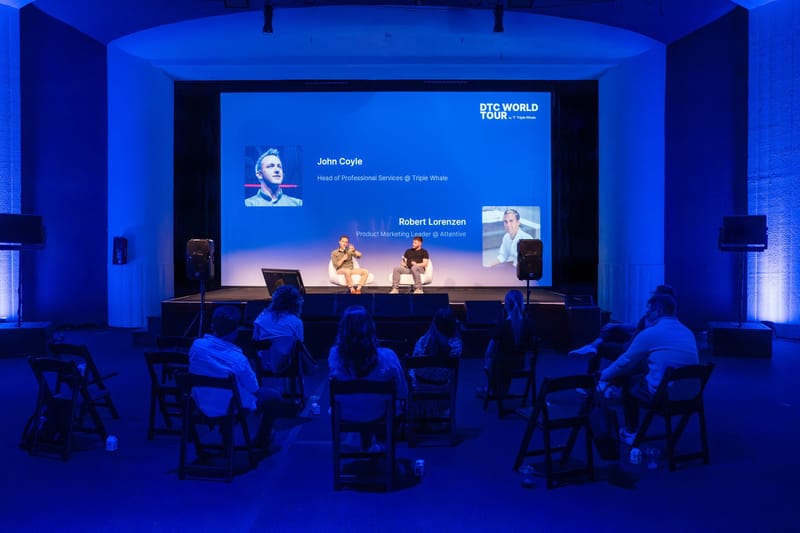 Panel on white chairs under a screen naming John Coyle of Triple Whale and Robert Lorenzen of Attentive