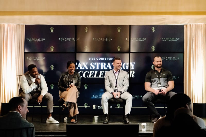 Four panelists on stage in front of a Tax Strategy Accelerator logo backdrop