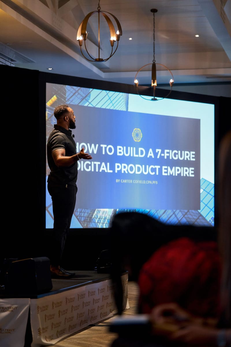 Speaker presenting a slide titled How to Build a 7-Figure Digital Product Empire