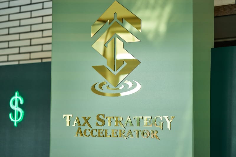 Gold Tax Strategy Accelerator logo mounted on a pale green wall beside a neon green dollar sign